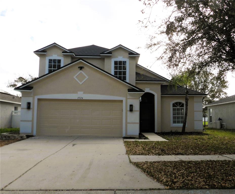 2324 Potomac Mark Place Ruskin, FL 33570 - Photo 2 of 38 a front view of a house with a yard and garage