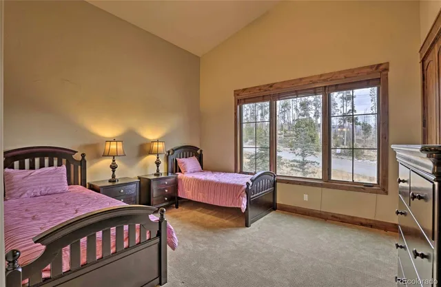 a spacious bedroom with two beds and large window