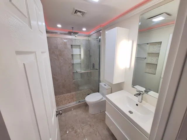 a bathroom with a sink a toilet and shower