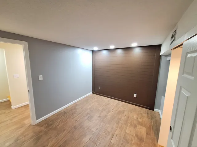 an empty room with wooden floor and entrance