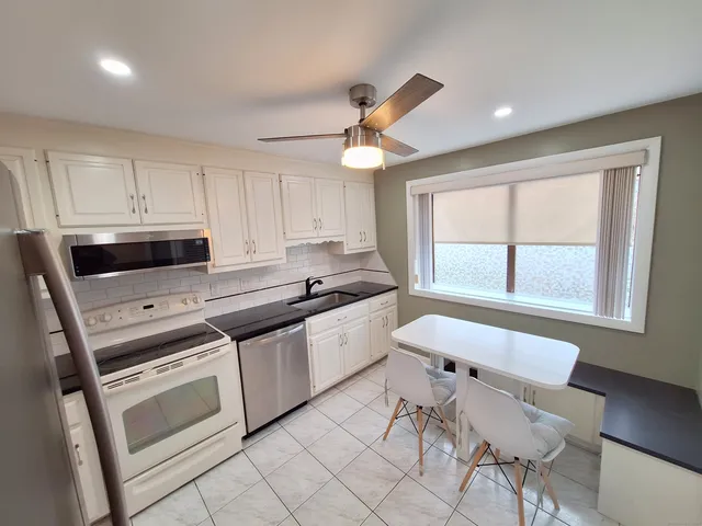 a kitchen with stainless steel appliances granite countertop a stove a sink and a refrigerator