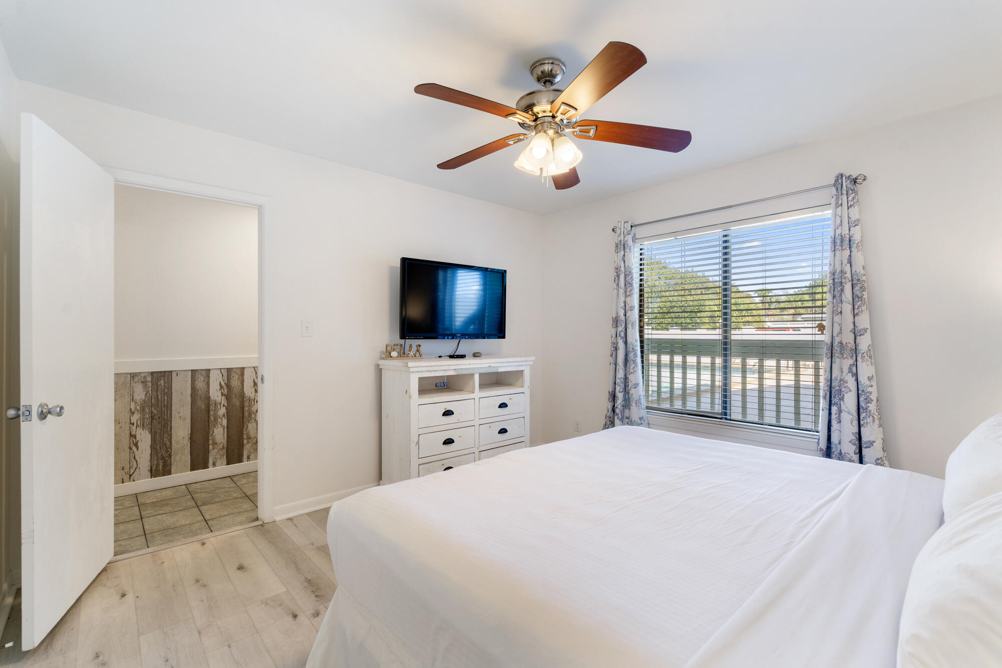 19504 Front Beach Road, Unit 1006 Panama City Beach, FL 32413 - Photo 19 of 34 a bedroom with a bed and a flat screen tv
