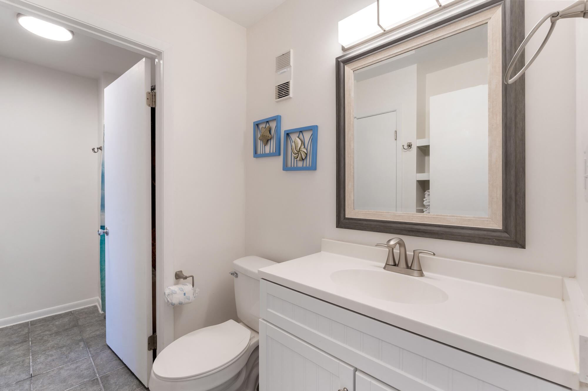 19504 Front Beach Road, Unit 1006 Panama City Beach, FL 32413 - Photo 24 of 34 a bathroom with a sink vanity granite toilet and a mirror