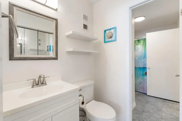 a bathroom with a sink a toilet and mirror