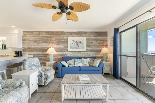 a living room with furniture and a floor to ceiling window