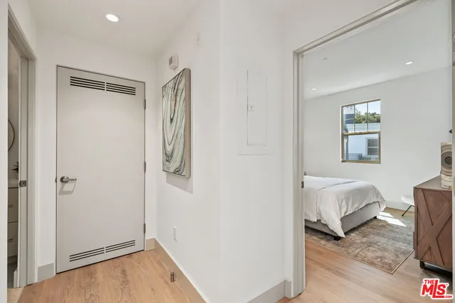 a view of a bedroom with wooden floor and hallway