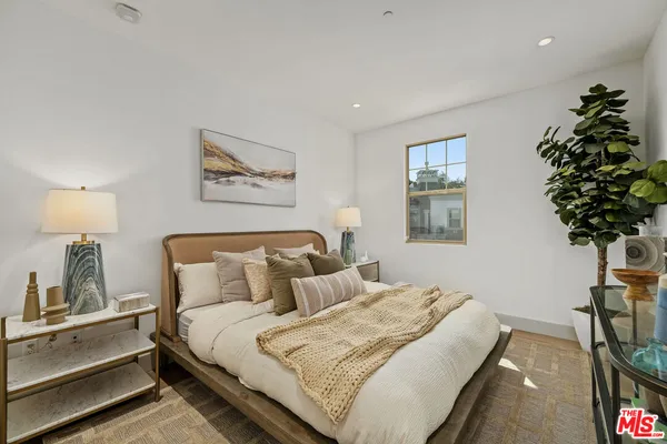 a bedroom with bed and a potted plant