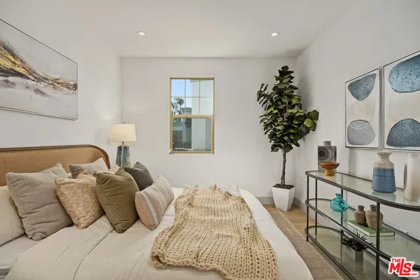 a bedroom with a bed and a potted plant