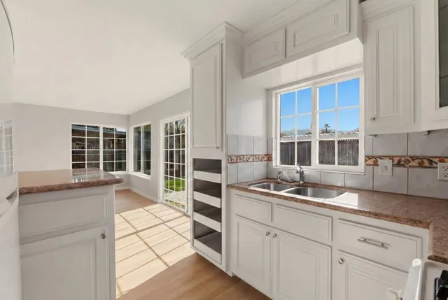 a view of a hallway with wooden floor and a bathroom