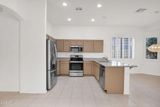 a large kitchen with stainless steel appliances granite countertop a stove and a refrigerator