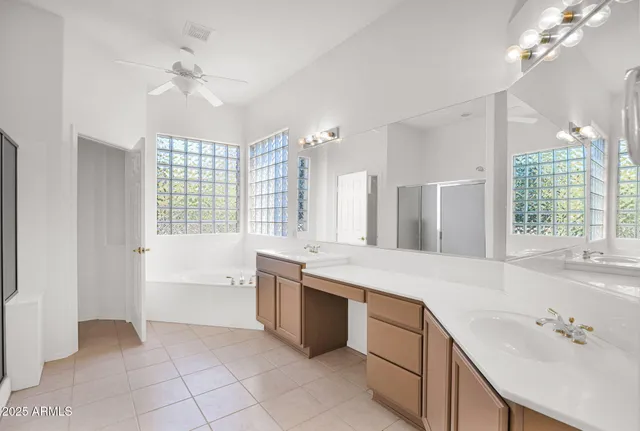a spacious bathroom with a granite countertop sink a large mirror and a bathtub