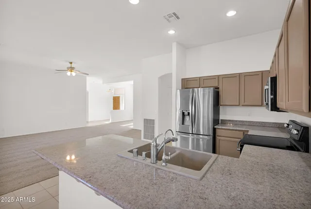 a kitchen with kitchen island a counter top space cabinets and stainless steel appliances