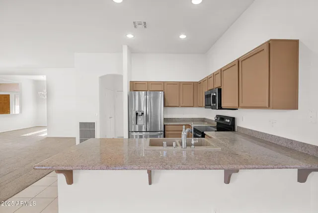 a kitchen with stainless steel appliances granite countertop a sink a stove and cabinets