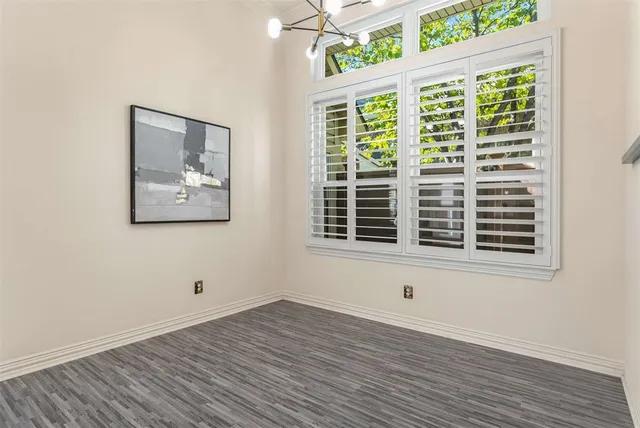 a view of a big room with wooden floor and windows