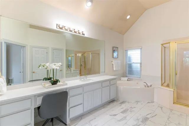 a bathroom with a double vanity sink a large mirror a bathtub and next to a window