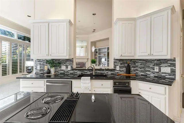a kitchen with stainless steel appliances a stove a sink a stove and white cabinets
