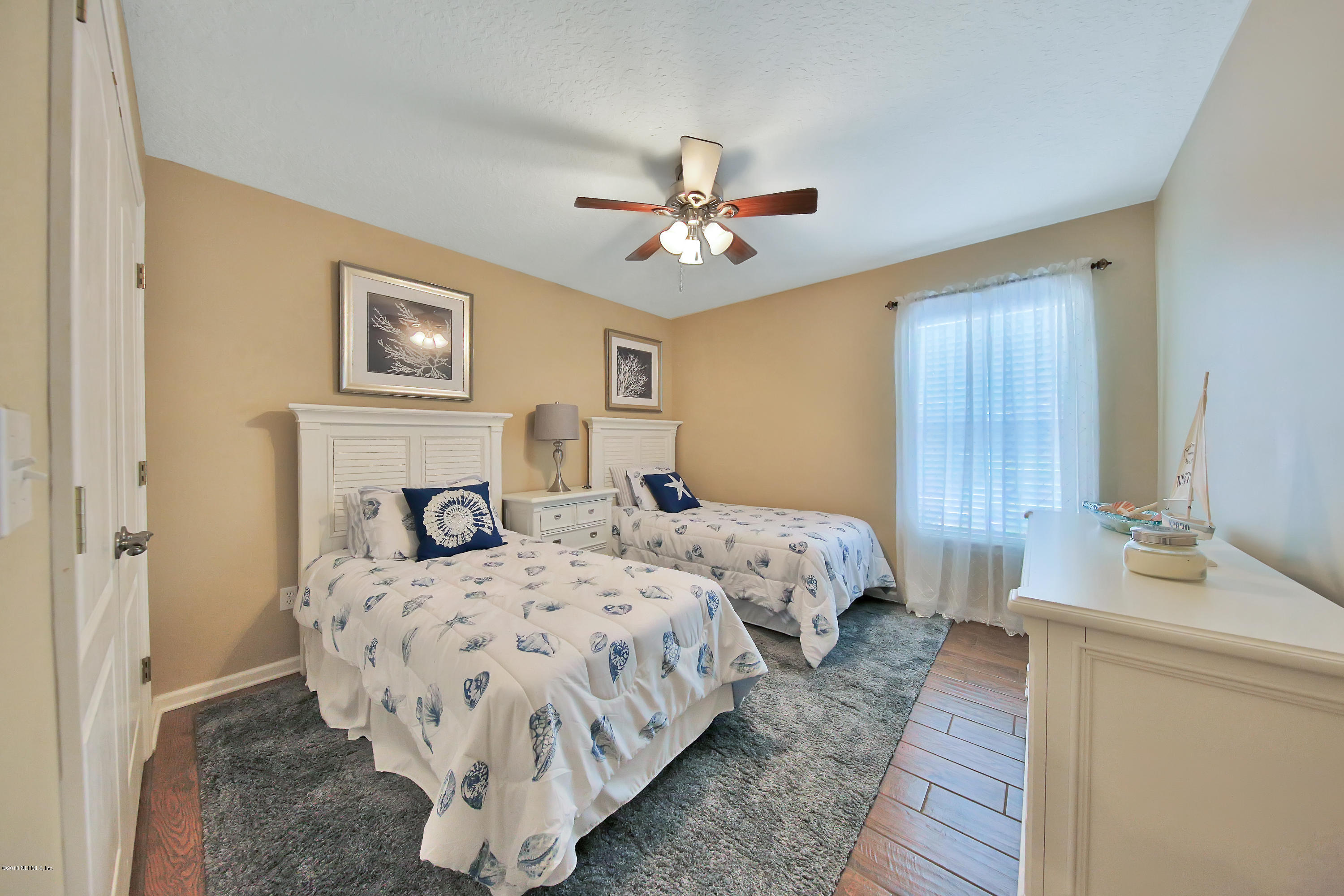 712 Porta Rosa Circle St. Augustine, FL 32092 - Photo 17 of 34 a bedroom with two beds and a chandelier