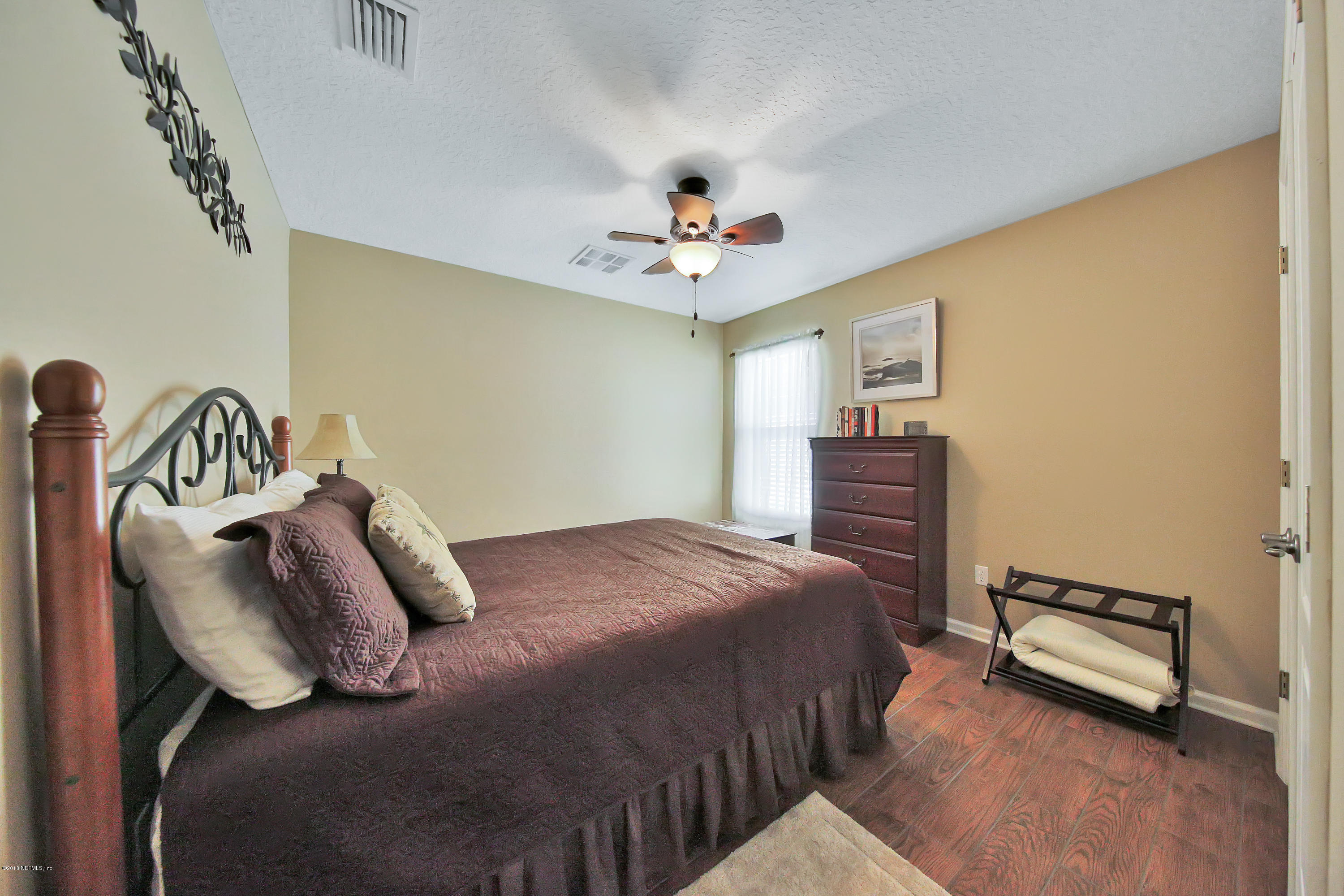 712 Porta Rosa Circle St. Augustine, FL 32092 - Photo 18 of 34 a bedroom with bed and a chandelier