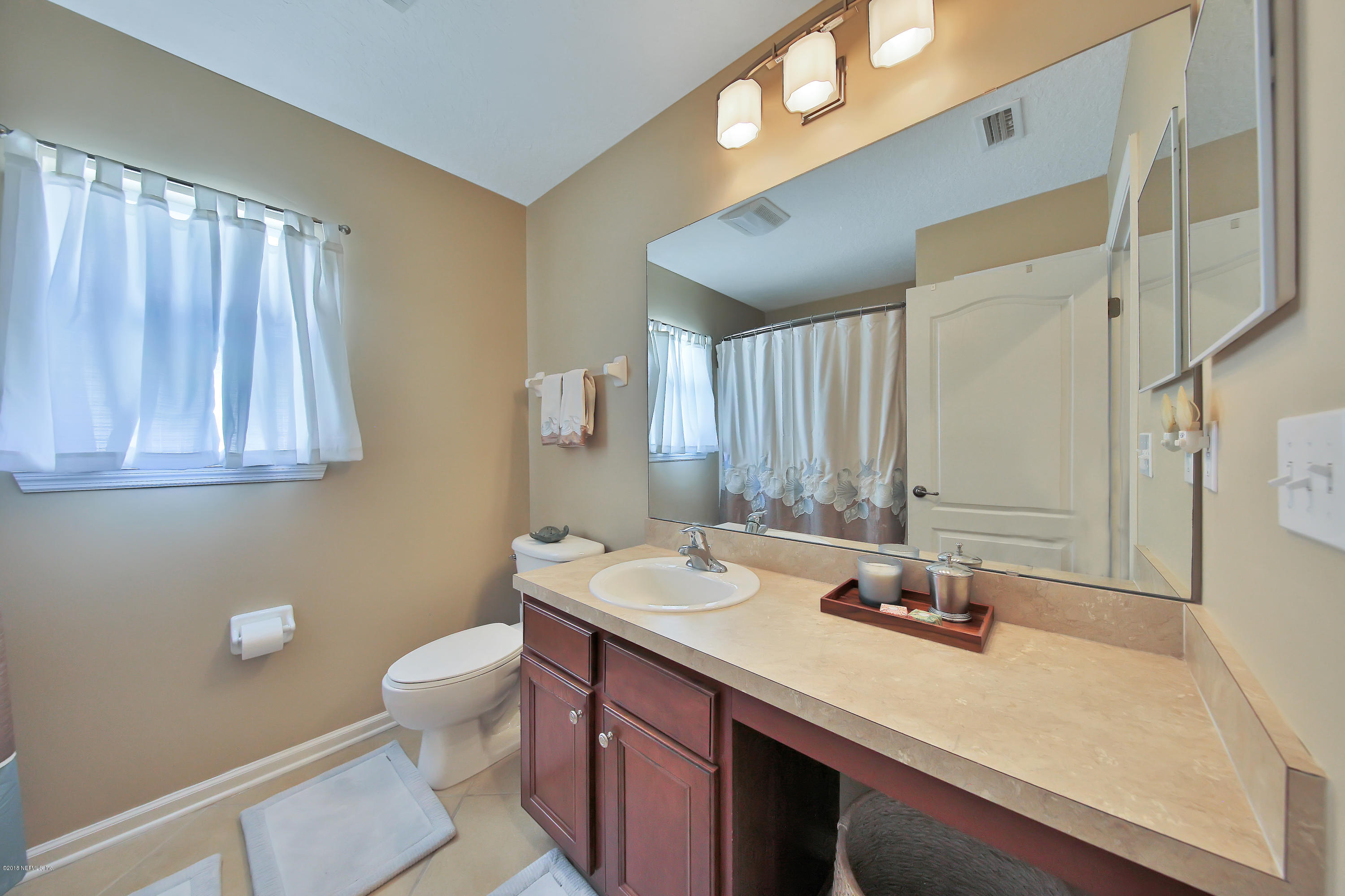 712 Porta Rosa Circle St. Augustine, FL 32092 - Photo 19 of 34 a bathroom with a sink a toilet and mirror