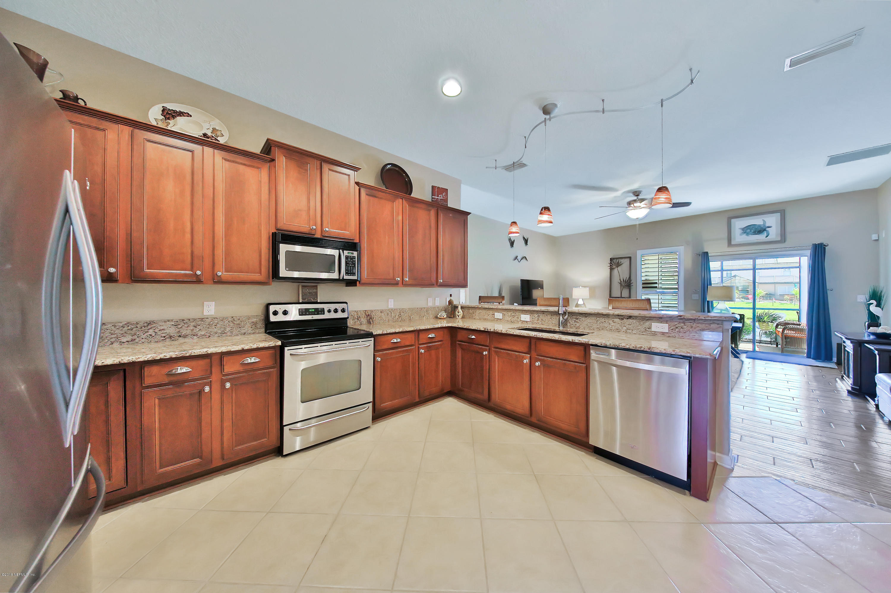 712 Porta Rosa Circle St. Augustine, FL 32092 - Photo 6 of 34 a kitchen with stainless steel appliances granite countertop a stove sink microwave and cabinets