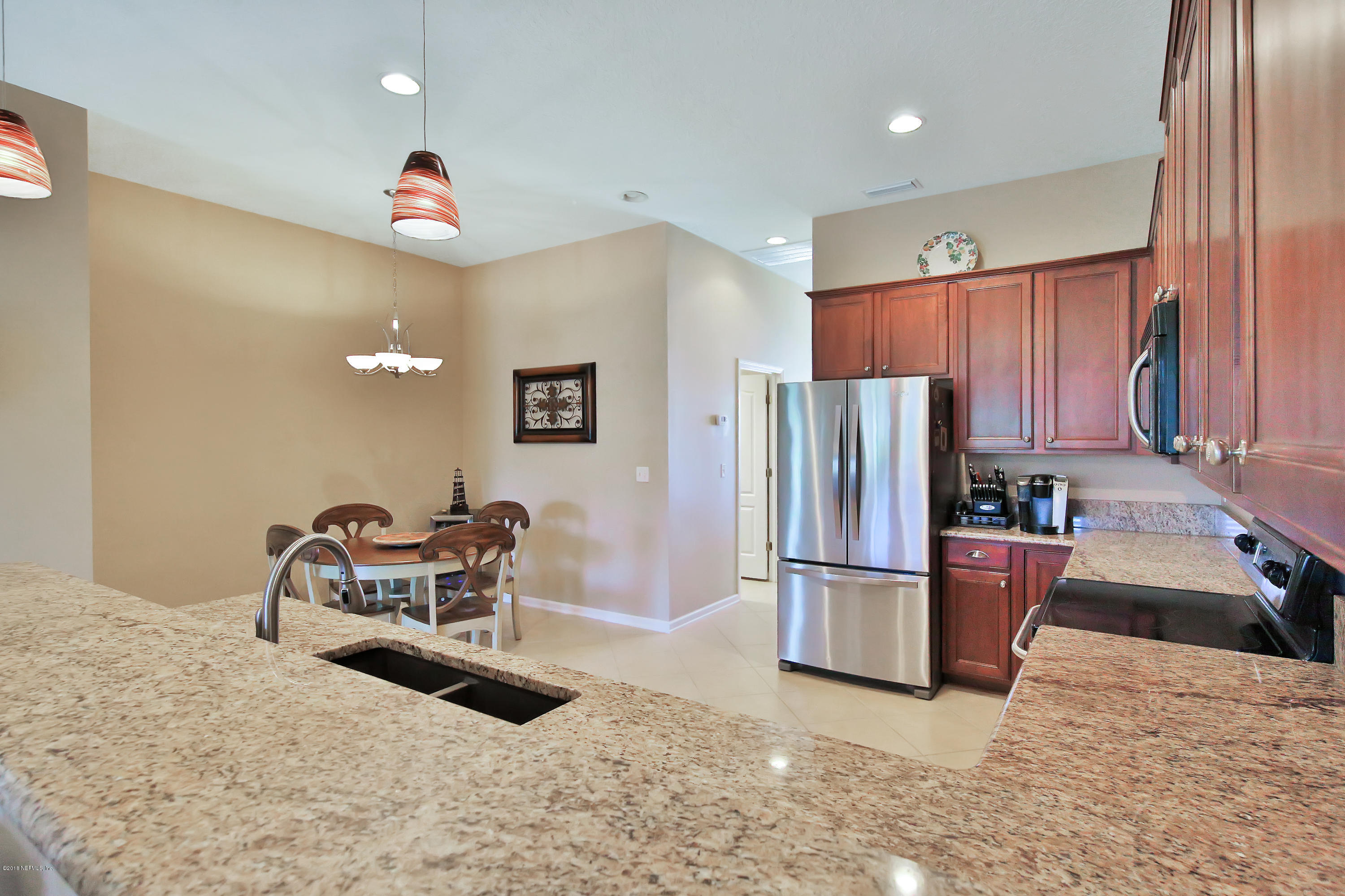 712 Porta Rosa Circle St. Augustine, FL 32092 - Photo 8 of 34 a kitchen with refrigerator and chairs