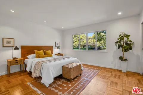 a bedroom with a bed and a potted plant