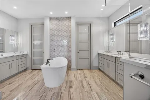 a spacious bathroom with a double vanity sink a mirror and a bathtub
