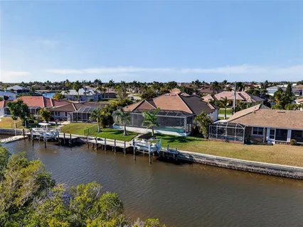 an aerial view of residential houses with outdoor space and lake view