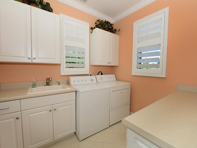 4259 Rigels Cove Way Jensen Beach, FL 34957 - Photo 11 of 22 a utility room with cabinets washer and dryer
