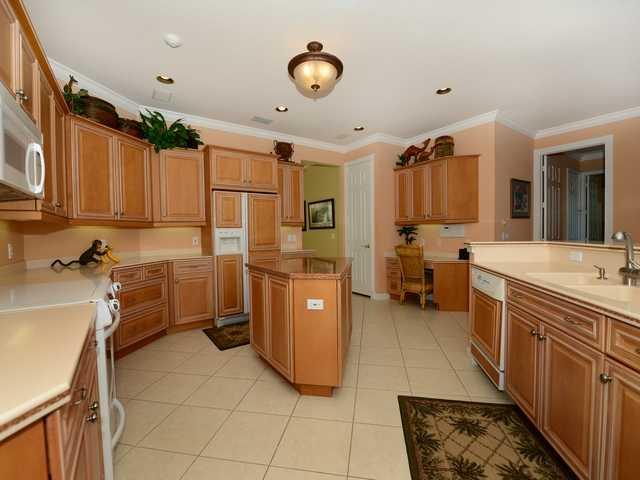 4259 Rigels Cove Way Jensen Beach, FL 34957 - Photo 5 of 22 a view of a kitchen with kitchen island a sink stainless steel appliances wooden floor and cabinets