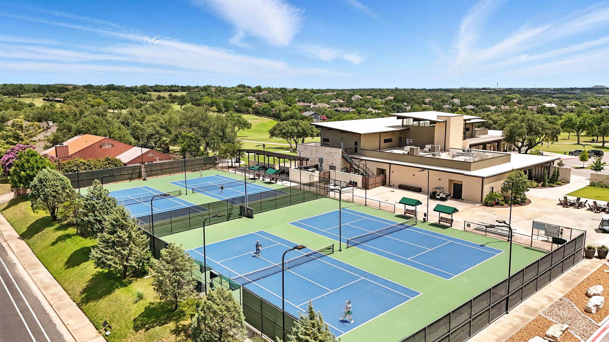 6905 Rudi Cove Austin, TX 78759 - Photo 35 of 37 Four tennis courts with pristine blue surfaces invite active recreation in this expansive outdoor setting.