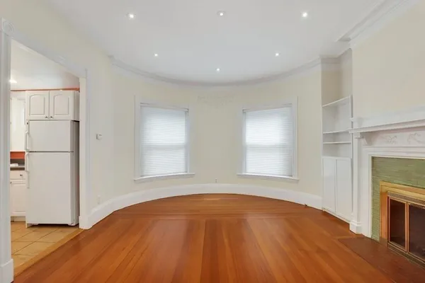 a view of empty room with wooden floor and fireplace
