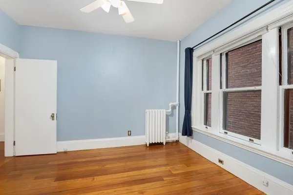 a view of a livingroom with wooden floor and a window