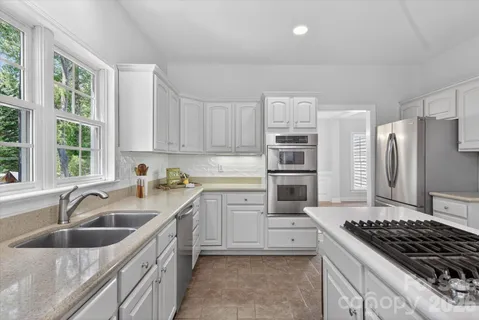 a kitchen with stainless steel appliances granite countertop a sink stove and refrigerator