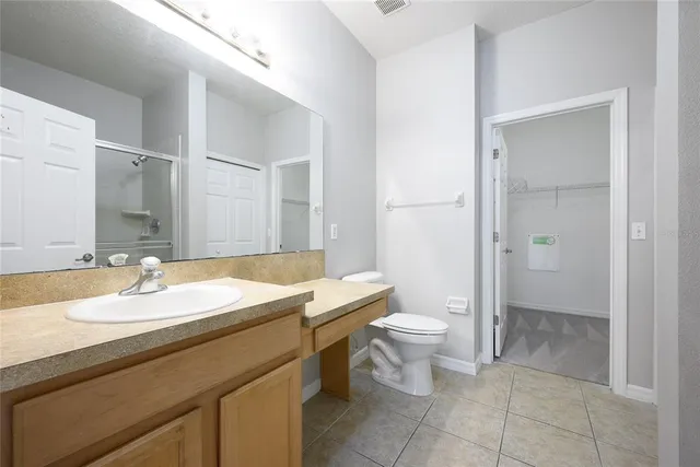 a bathroom with a granite countertop sink a toilet and a mirror