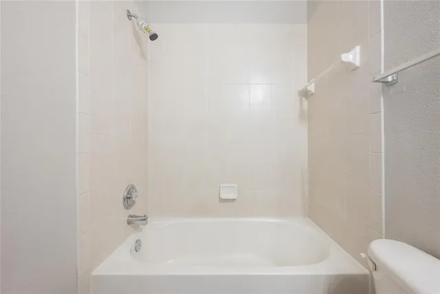 a white bath tub sitting next to a white sink and vanity