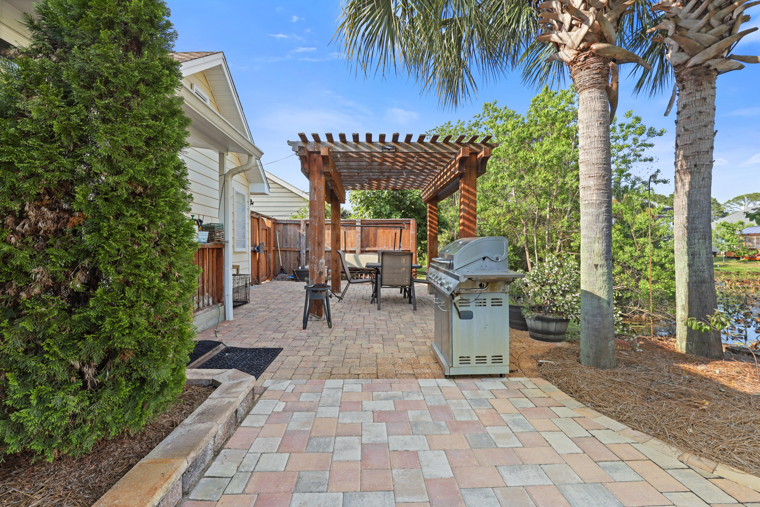 90 Hidden Lakes Drive Miramar Beach, FL 32550 - Photo 16 of 18 a view of a patio with table and chairs potted plants and palm trees