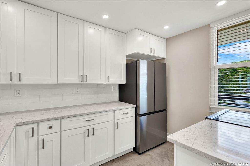 1950 Southwest Palm City Road, Unit 14305 Stuart, FL 34994 - Photo 28 of 70 a kitchen with stainless steel appliances white cabinets and a refrigerator