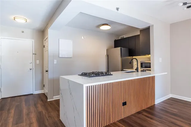 a kitchen with a sink and a stove top oven with wooden floor
