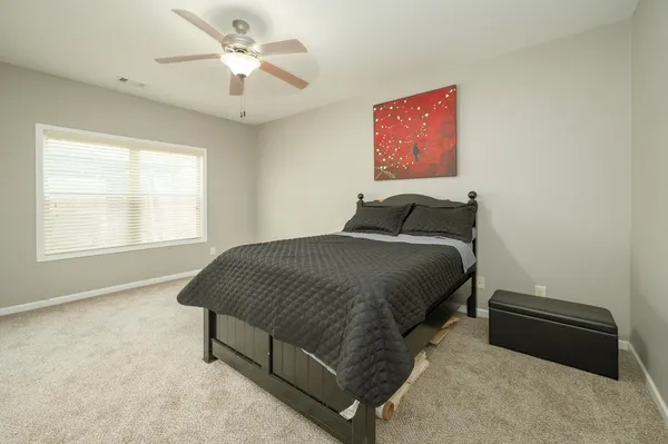 an empty room with a window and a fan