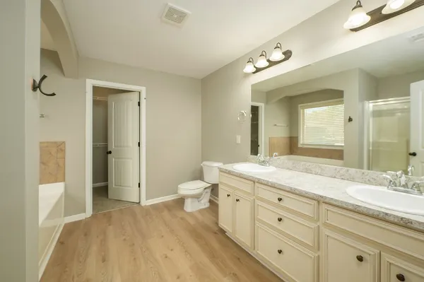 an empty room with windows and ceiling fan