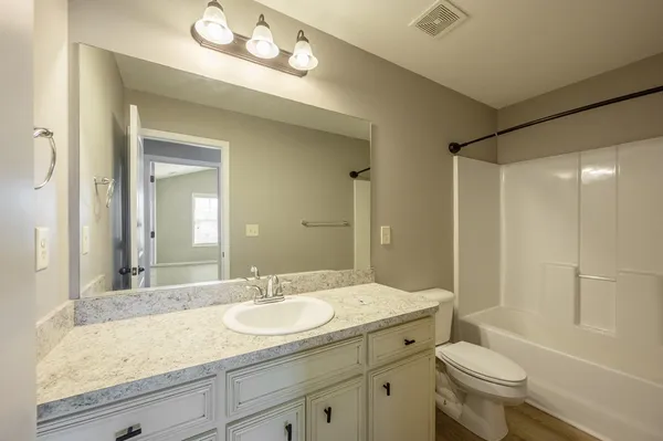a bathroom with a tub a sink and a mirror