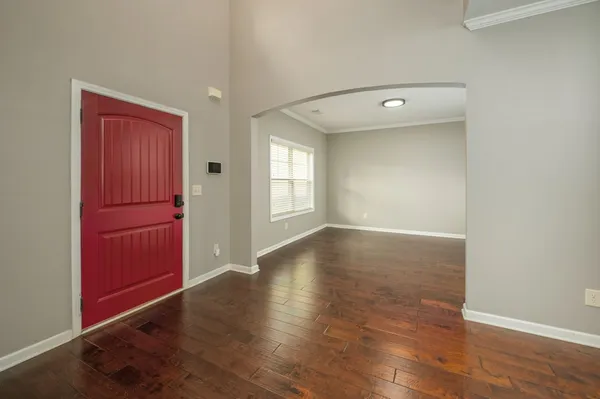 a view of a living room with kitchen view and wooden floor