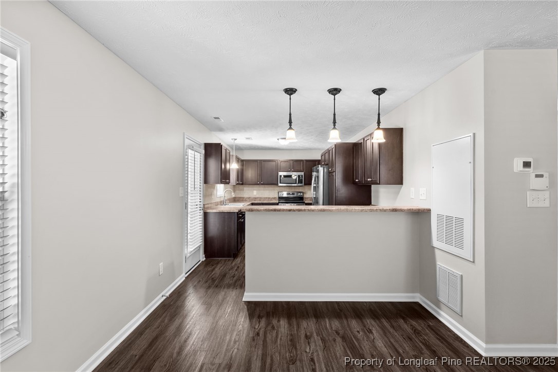 186 Scanner Court Raeford, NC 28376 - Photo 17 of 49 a kitchen with kitchen island wooden floor center island and stainless steel appliances