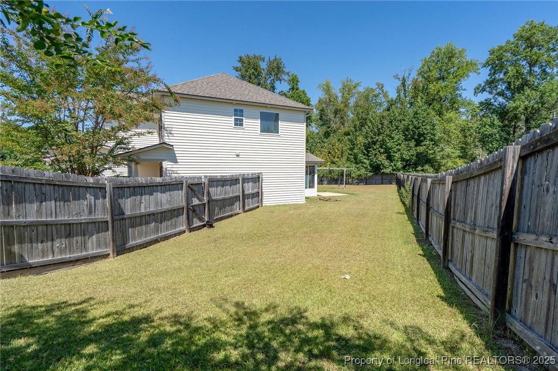 186 Scanner Court Raeford, NC 28376 - Photo 45 of 49 a view of backyard with small cabin and wooden fence