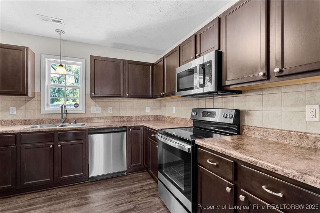 186 Scanner Court Raeford, NC 28376 - Photo 9 of 49 a kitchen with stainless steel appliances granite countertop a sink a stove and cabinets