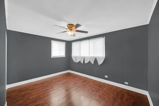 an empty room with windows and wooden floor