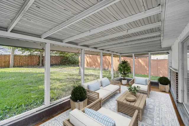 a living room with large windows and furniture