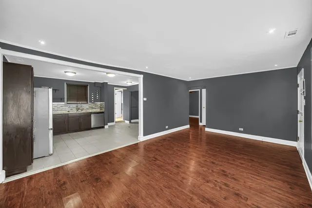 a view of a kitchen with a sink and an empty room