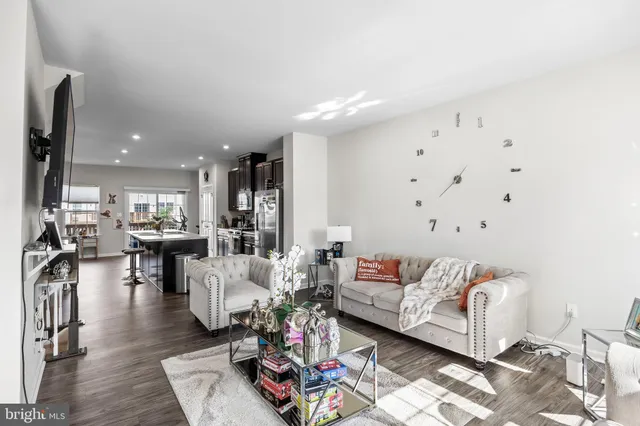 a living room with furniture and view of kitchen